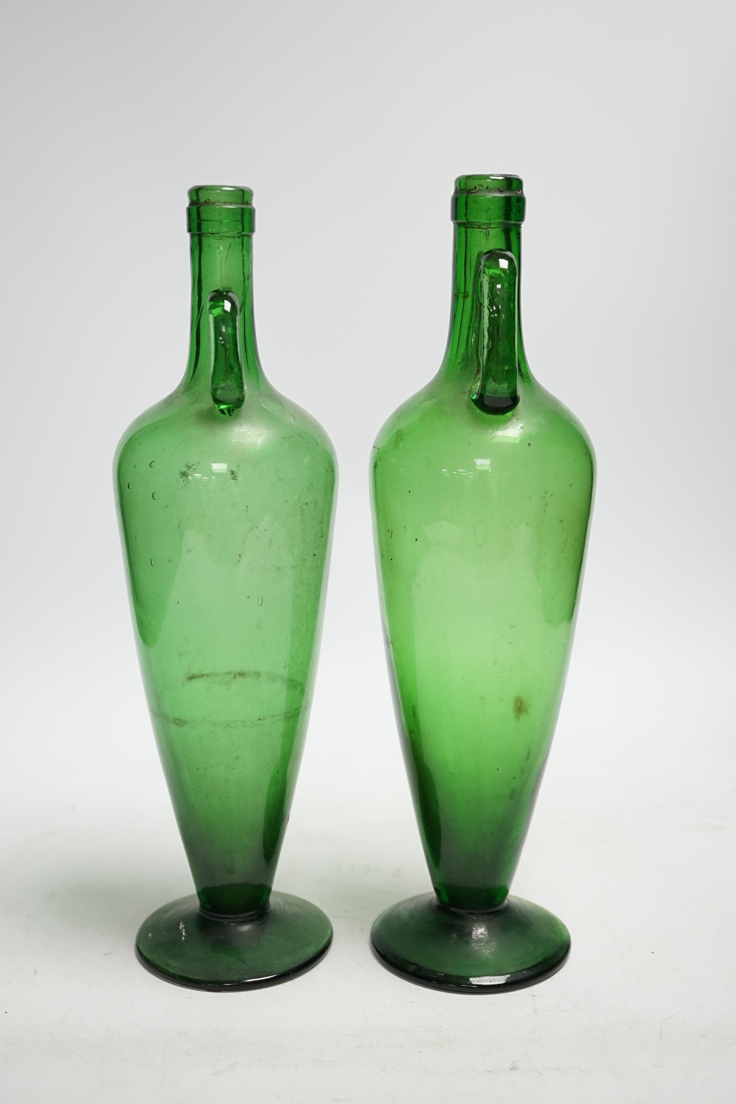 A pair of double handle green glass vases, 33cm